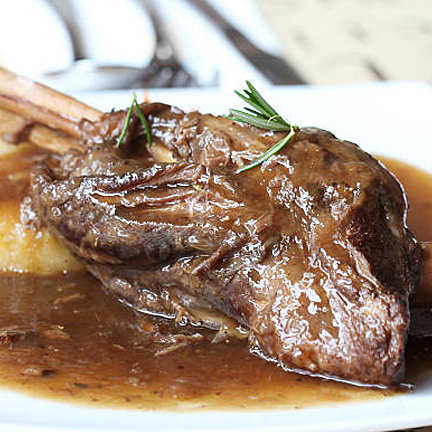 Braised lamb shank dinner infused with white wine, herbs, and spices
